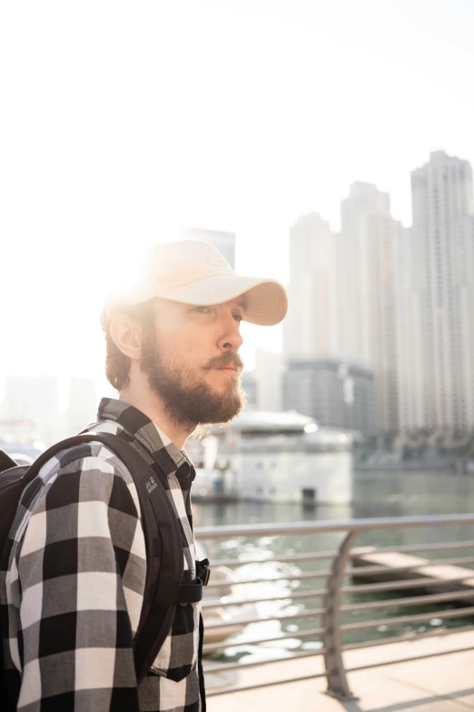 a man with a beard, cap and backpack on