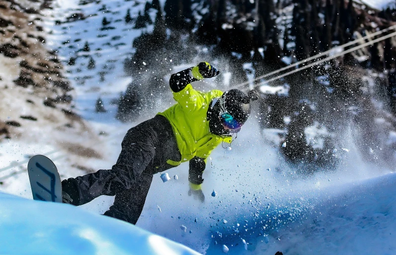 a snowboarder in yellow is airborne on his board