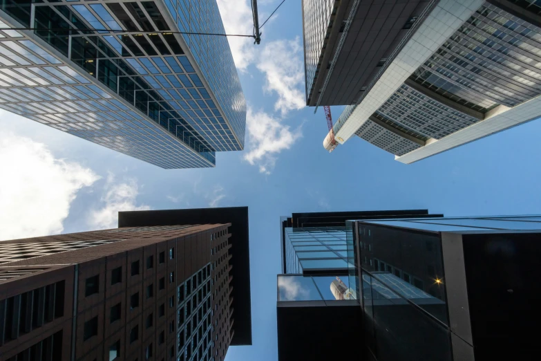 looking up at several high rise buildings in a city