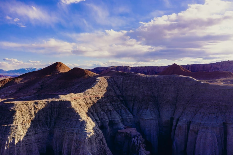 a landscape with mountains on one side and clouds in the other