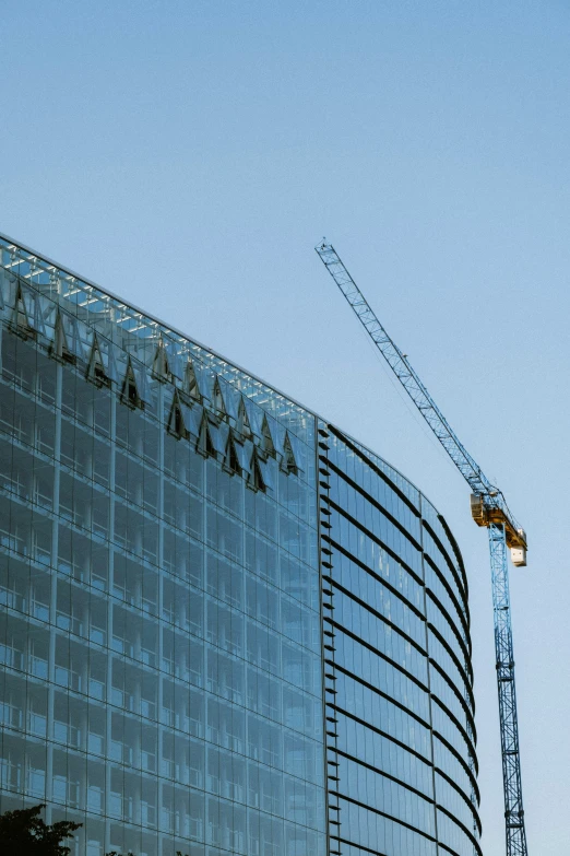 a large crane in front of a very tall building