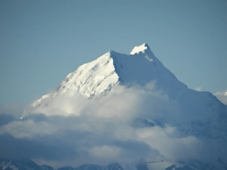 a snowy mountain covered in white clouds