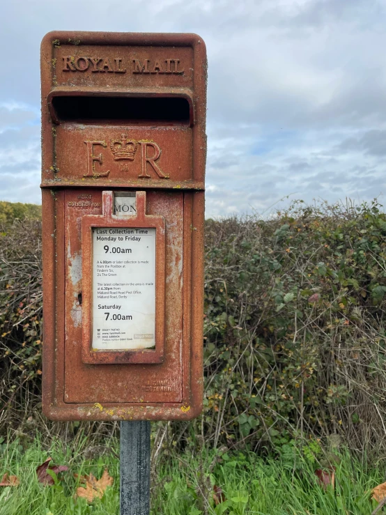 old rusty mail box near grassy area under blue sky