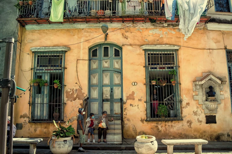 the street corner has old looking buildings with laundry lines hanging over them