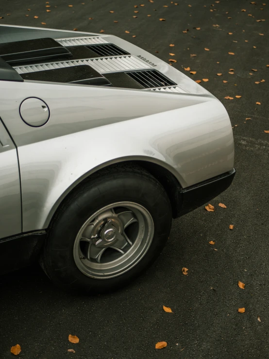 the top of a silver sports car sitting on a parking lot