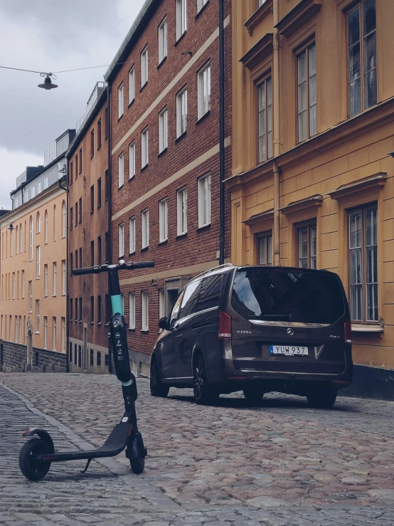 a van parked on the side of the street next to parked mopeds