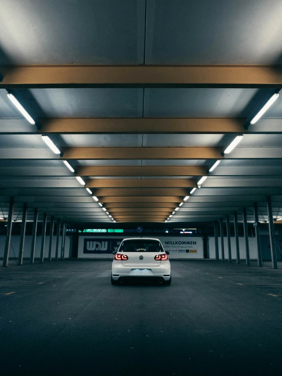 car parked in parking garage with lights hanging above