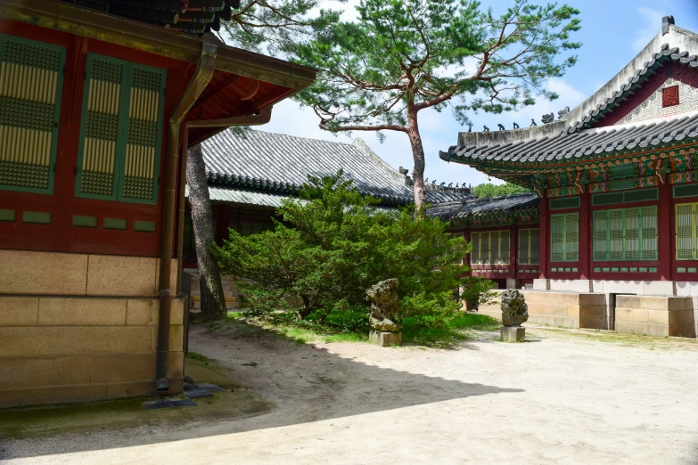 a stone walkway between two building with trees