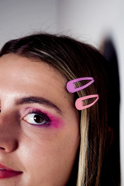 a close up of a woman with a pair of scissors in her hair