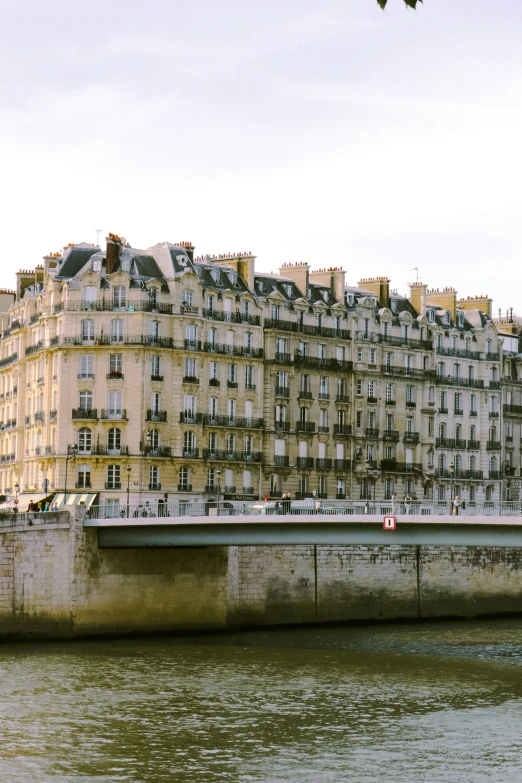 view of an old apartment building from across a river