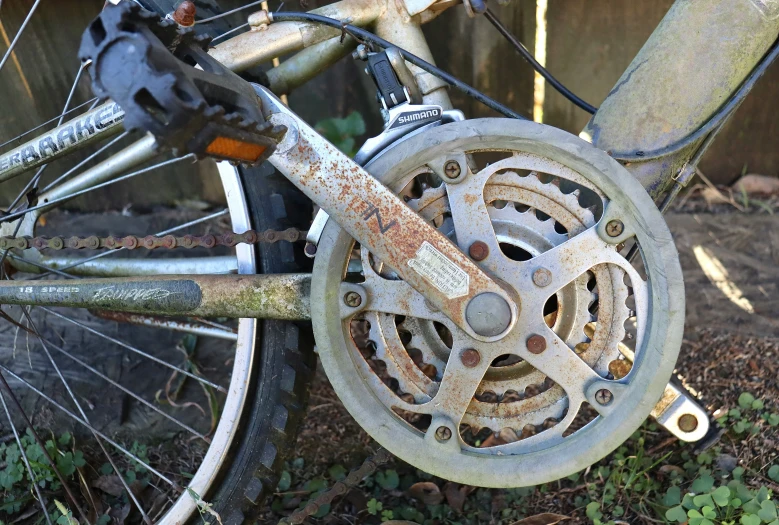 a dirty old bike outside near a building