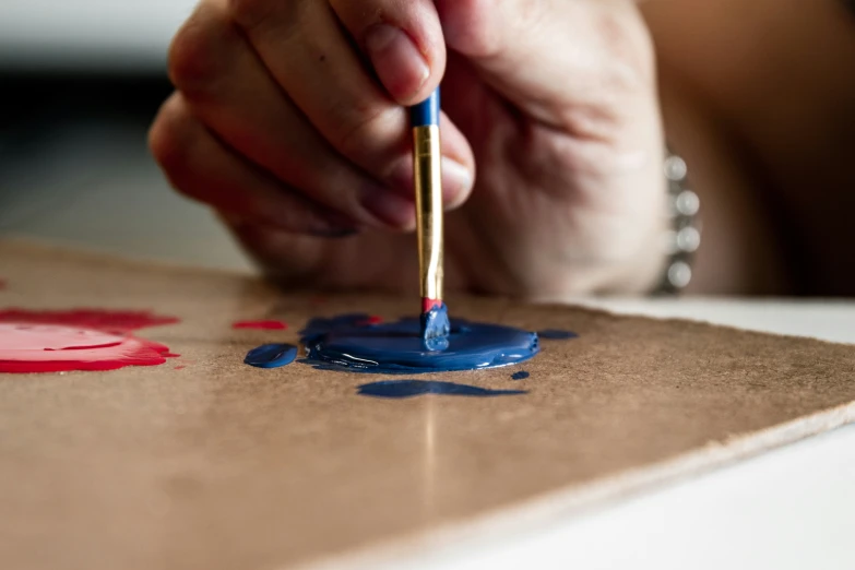 a person with a blue paintbrush painting soing