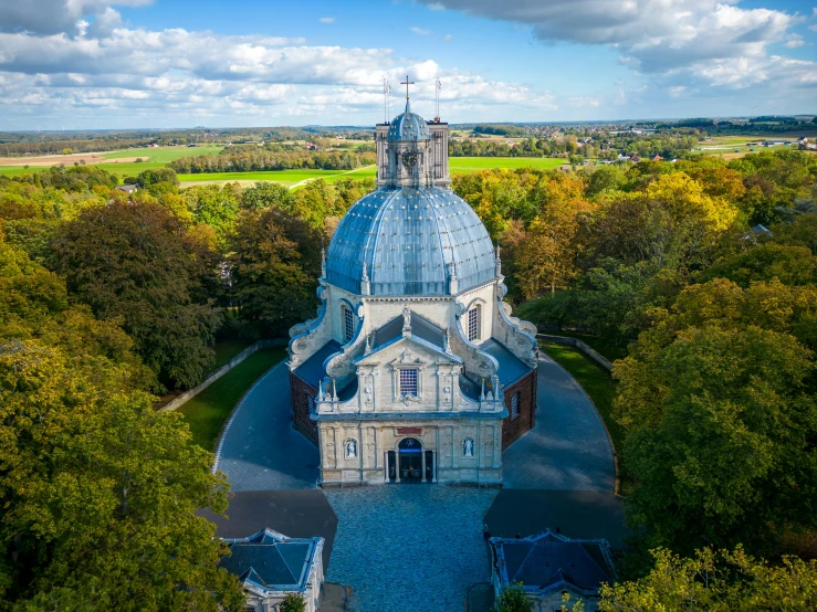a bird's - eye view of the top of a church surrounded by trees and bushes