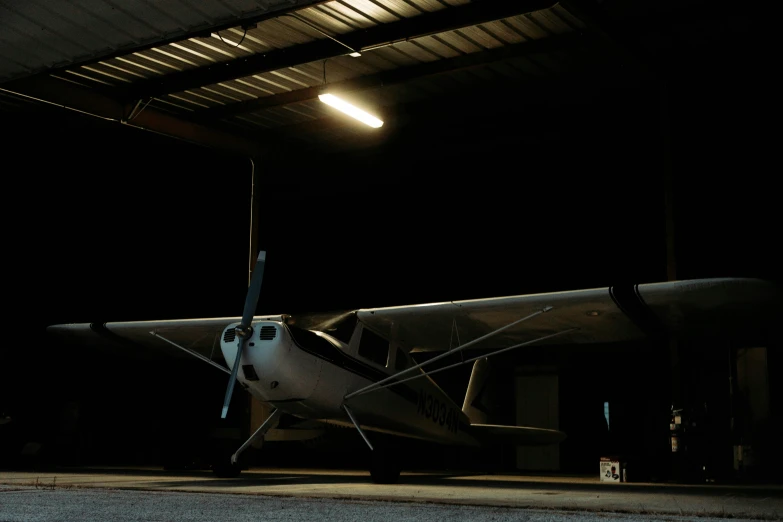 a small airplane parked inside a building on a dark day