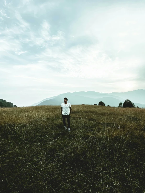 a man standing in an open field in the day