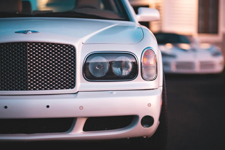 a white passenger car is parked on the side of the street