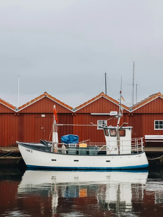 a small fishing boat in the water near many wooden buildings