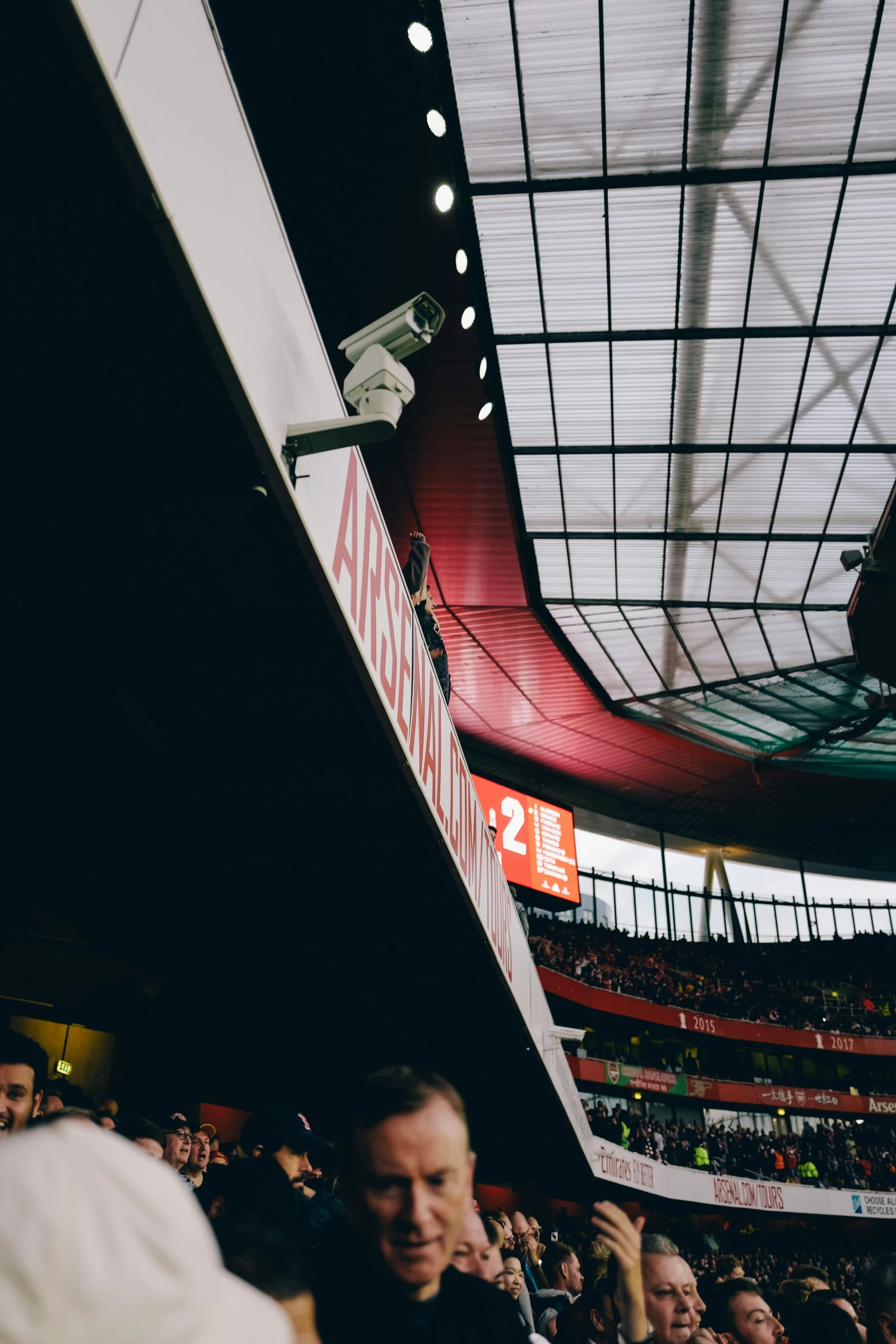 a crowd of people are standing in a sports arena