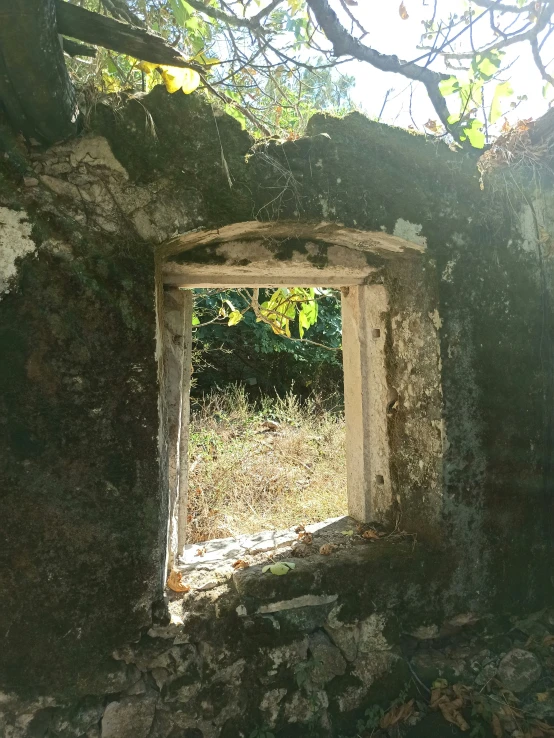 a doorway with stone walls and green grass