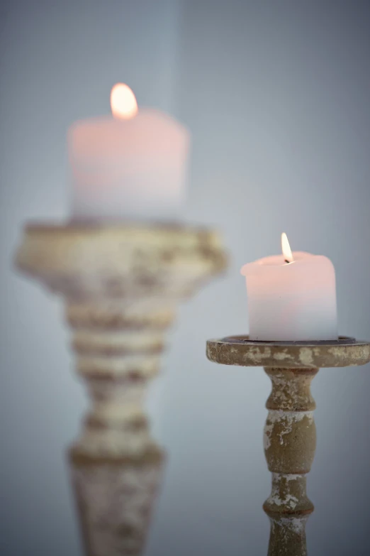 a candle sits on a table near two candles