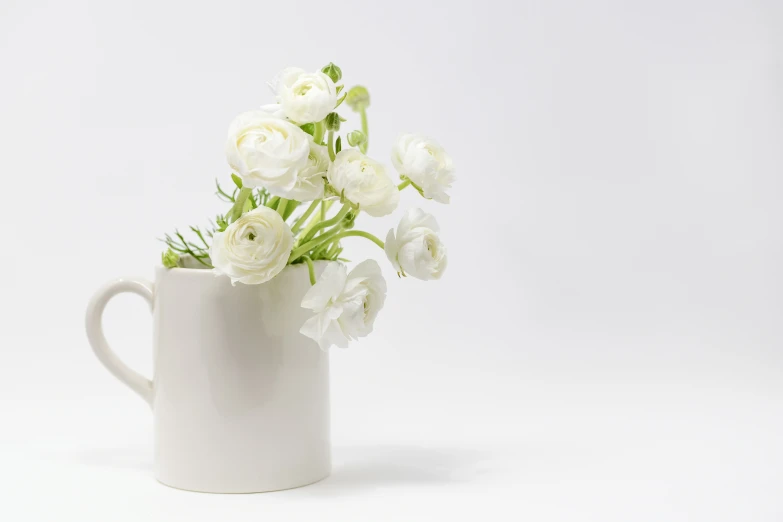 a white coffee mug with flowers in it