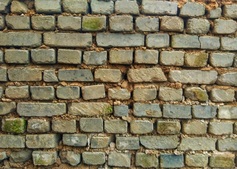 a very old brick wall is shown with stones