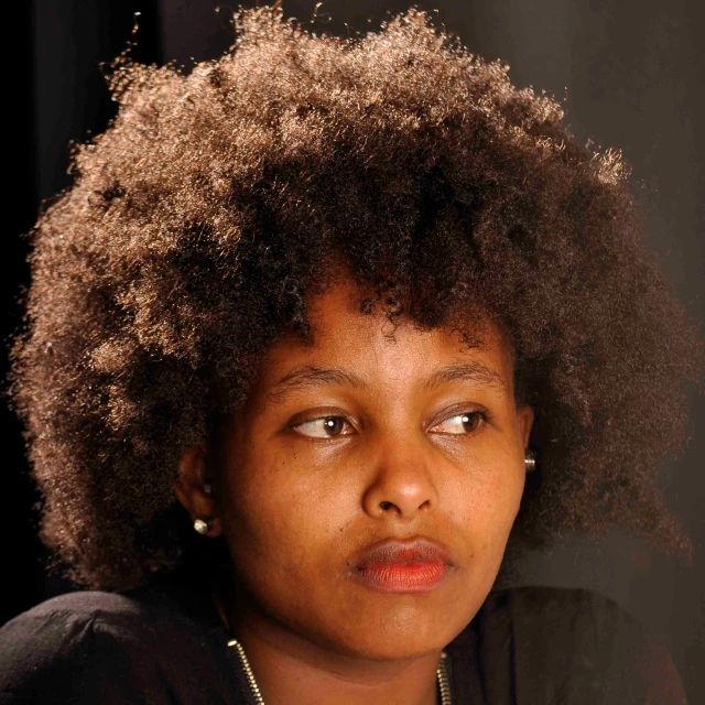 a woman with an afro looks into the camera