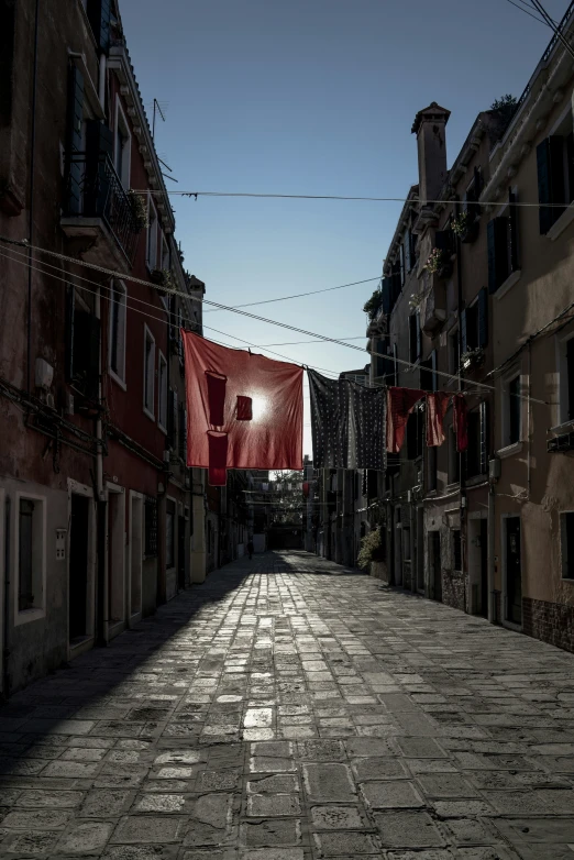 a street with houses lining it and one red flag hanging on the building