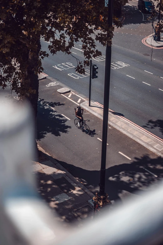 an aerial s of a person riding a bicycle down the road