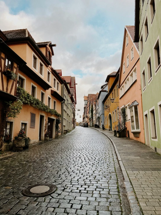 a brick road going between old buildings on either side