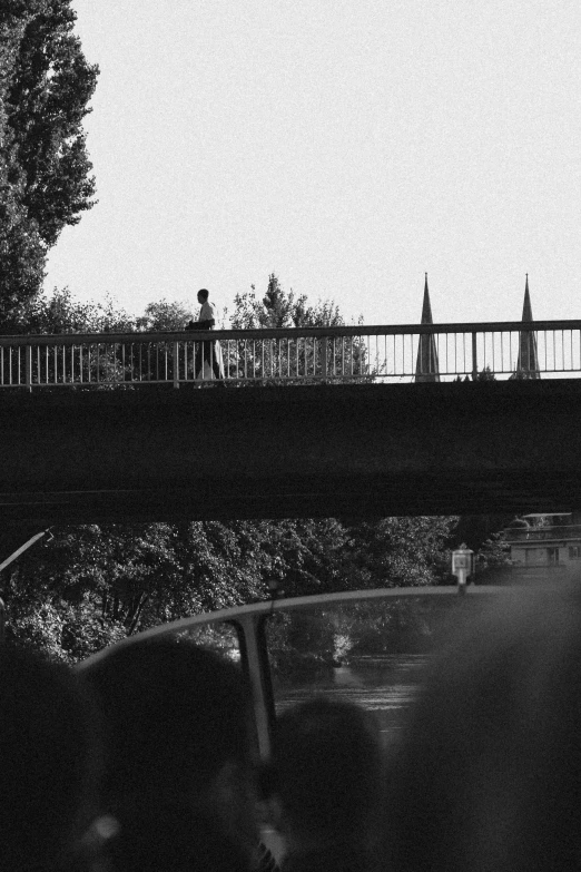 people are walking on a bridge over water