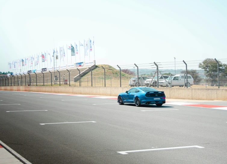 a blue sports car on an empty road