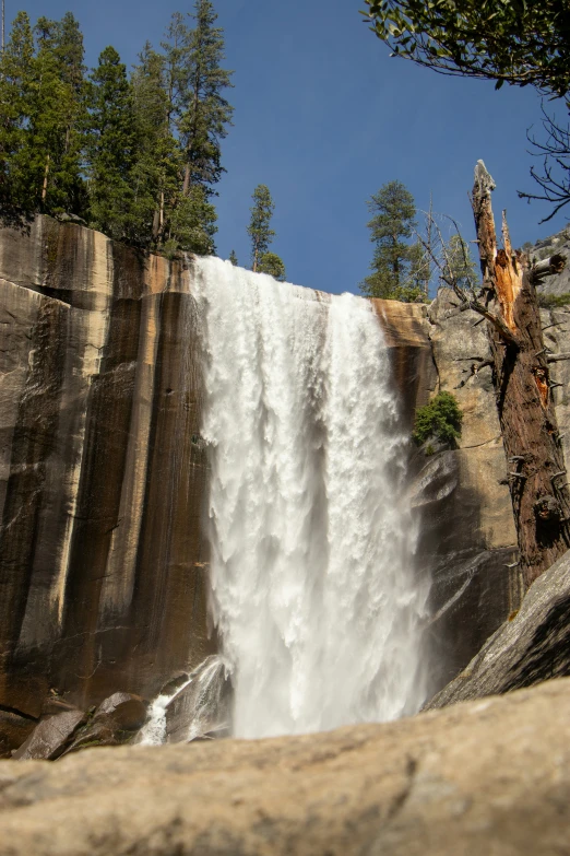 a man standing on top of a large waterfall