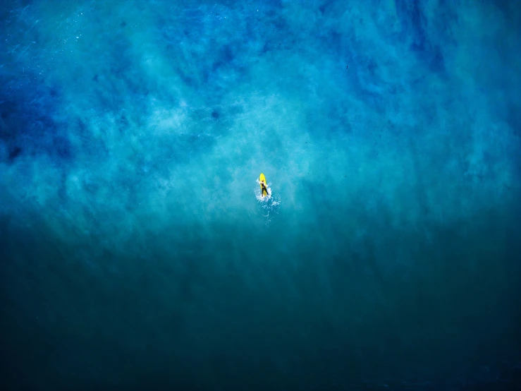 a white and yellow boat in the middle of a blue ocean