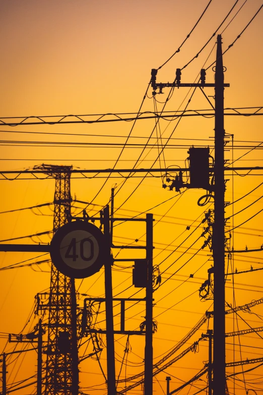 power lines that are over looking an orange sky