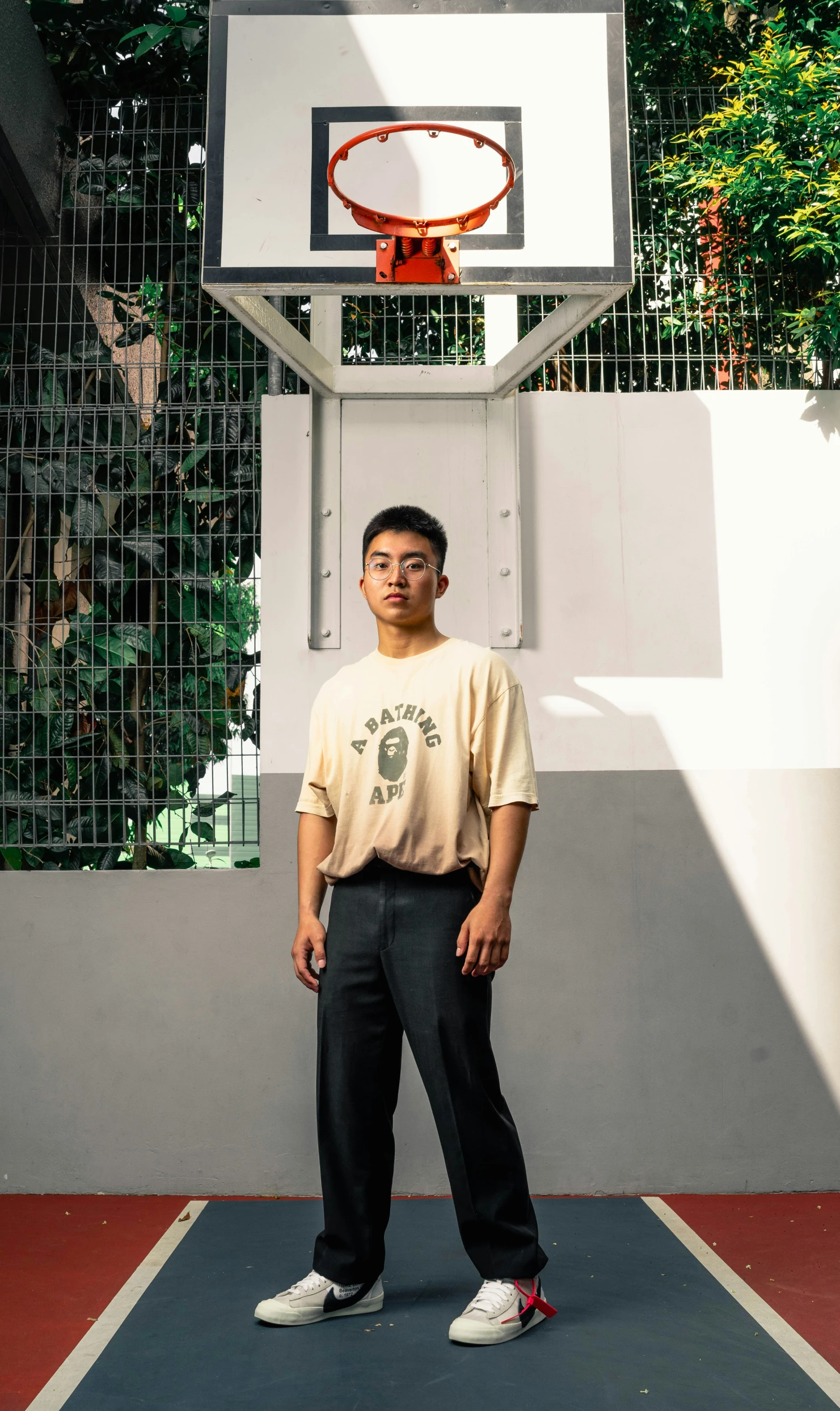 a young man standing in front of a basketball hoop