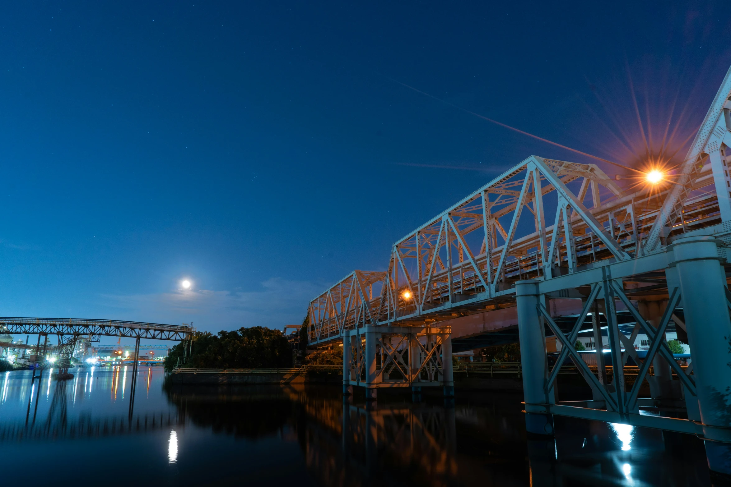 a long view of a bridge at night with the light up