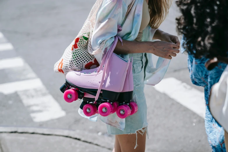 a young woman holding a pink bag with pink roller skates on it