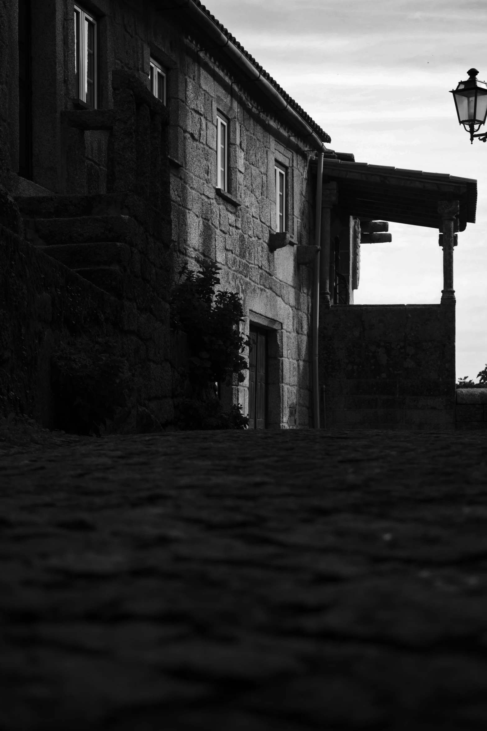 an alley way with brick houses and a lamp post