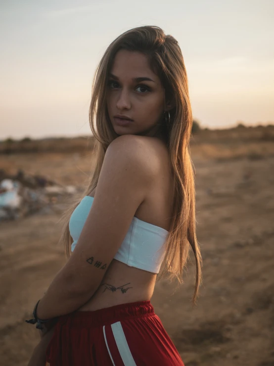 a girl in a red skirt standing on the beach