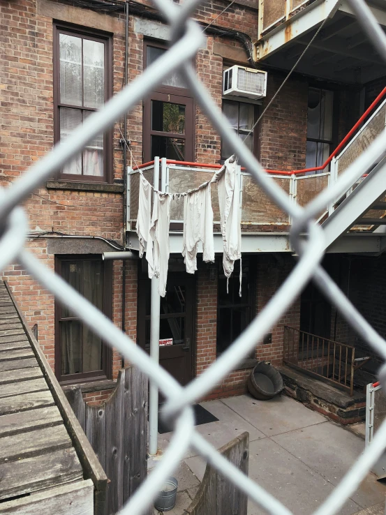 a building that has a number of hanging clothes in the yard