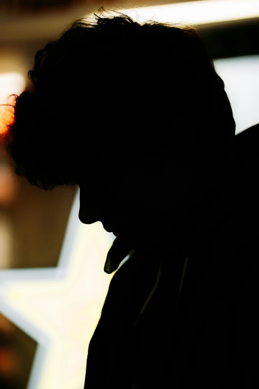 a man with his back to the camera in dark shadow