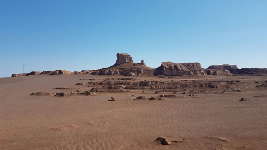 a desert with rock formations and no one in the background