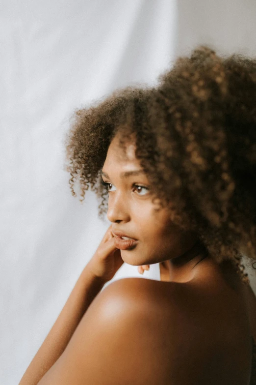 the woman with curly hair is posing for a picture