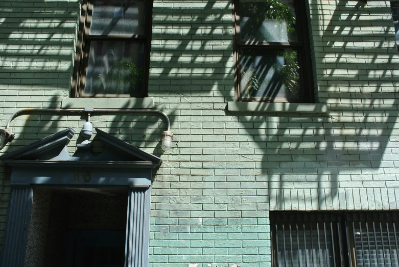 an old white brick building with two windows