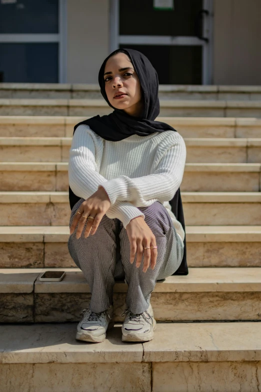 a young woman is sitting on the steps of an auditorium