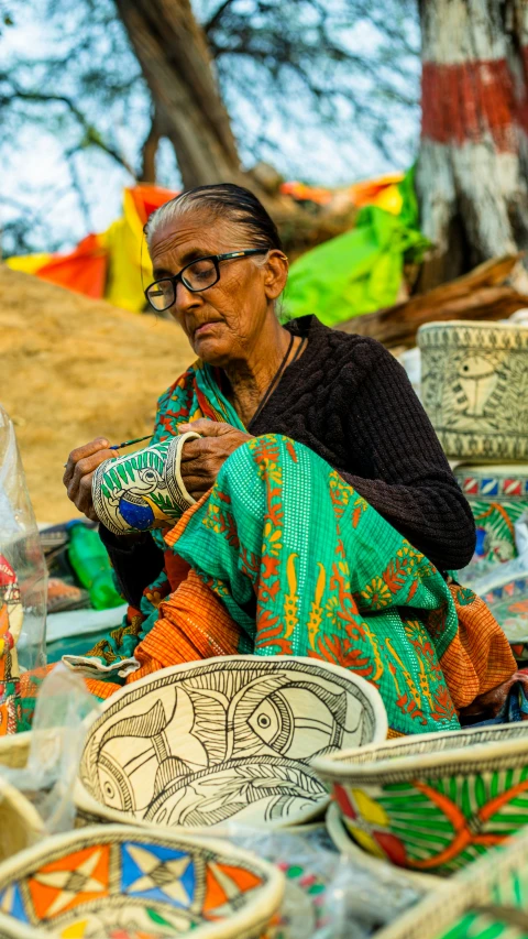 an old woman with glasses weaving on her fingers