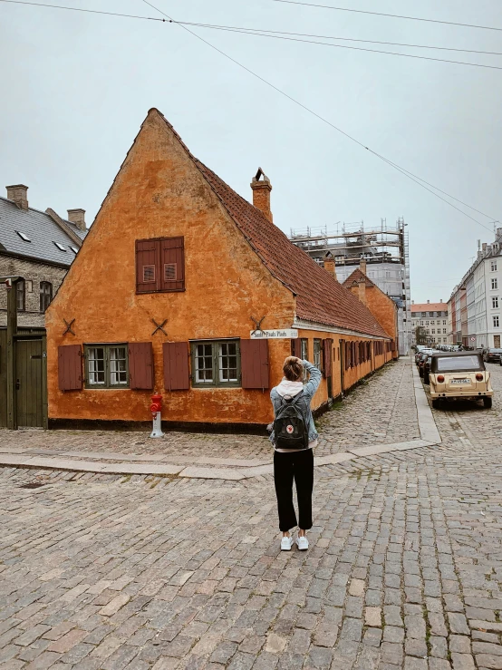 a person stands on a brick road and looks out at the buildings