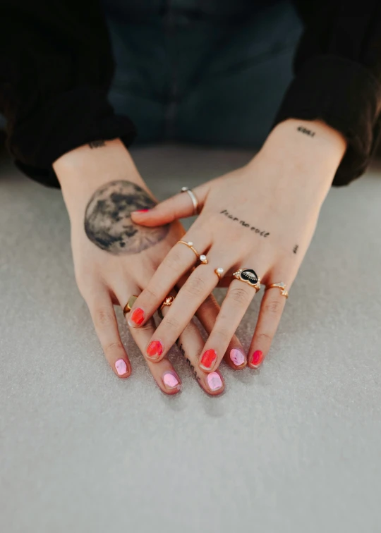 a womans fingers and a bunch of rings on her left hand