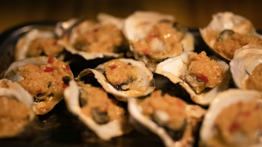 a table topped with a pile of raw oysters